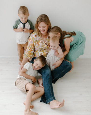  Lifestyle detail of mother and daughter sitting together, child wearing pink sneakers and bandaid