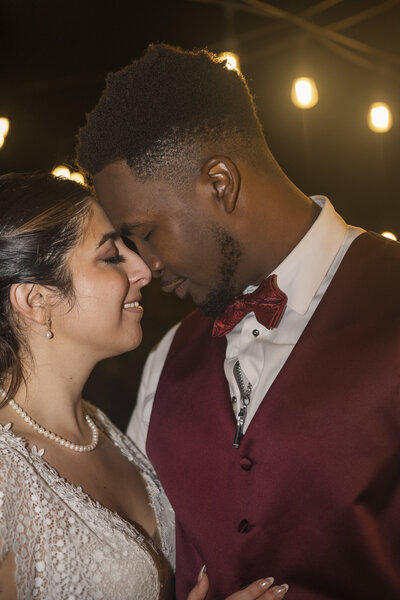 Bride and groom in front of lights in the dark