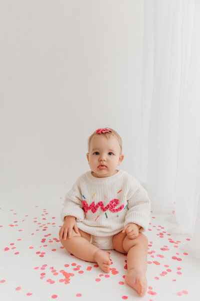 baby in white sweater for baby milestone session in phoenix
