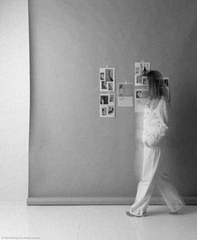 photograph of woman by a moodboard wall walking