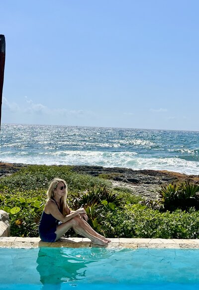 woman poses in front of the ocean