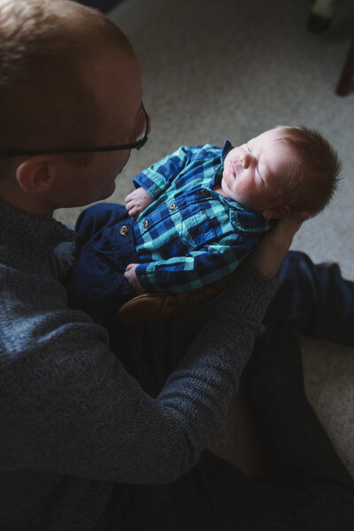 Newborn Photo taken of baby looking at the camera | Taken By Maine Photographer who photographs in places like Rangeley, Sugarloaf, Bar Harbor, and more in Maine