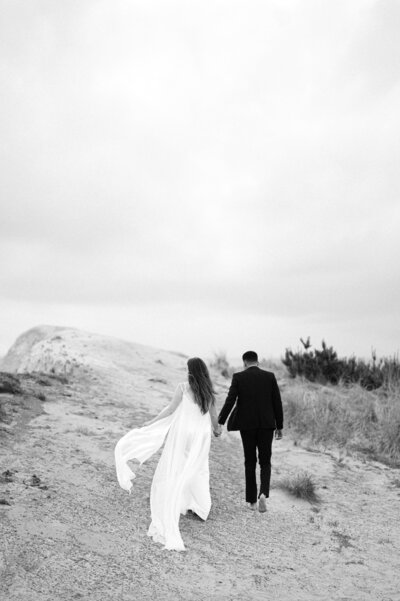 Bride and groom walking together along the Oregon coast