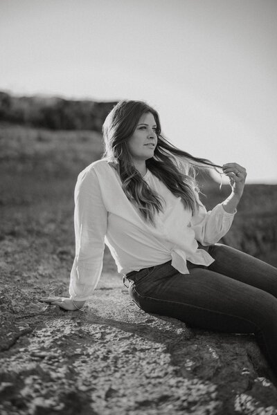 wedding photography woman owner sitting on rock for engagement photos