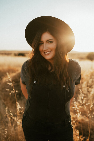 Photographer Aspen Dawn  in a black hat at sunset.