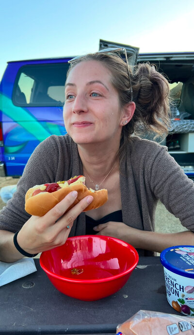 Katie eats a hot dog while crying happiness.