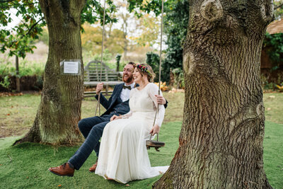 bride and groom on tree swing