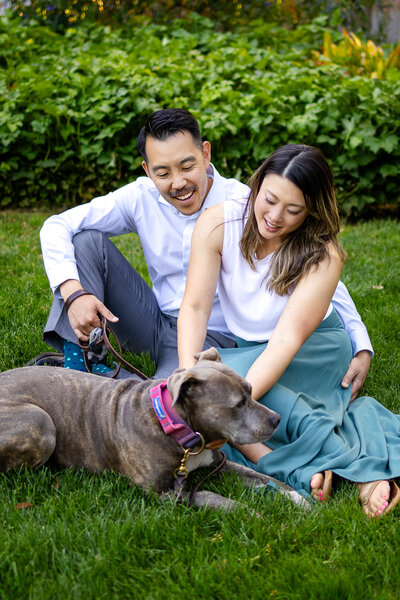  A couple lounges on the lawn with their senior dog during a laidback family session with Ellobelle Photography.