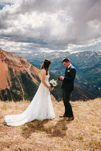 Groom helps bride into jeep in the yankee boy basin in  Ouray, Colorado.