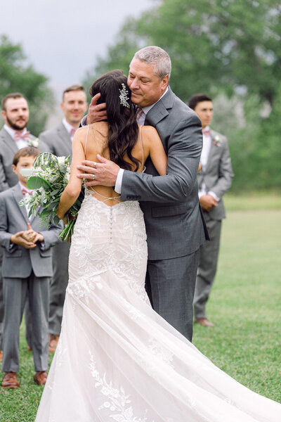 bride hugging father before ceremony- large