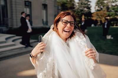 Casey McKenna, founder of Most Valuable Bridesmaid Day-of Coordinator Team laughing wearing a bridal veil.