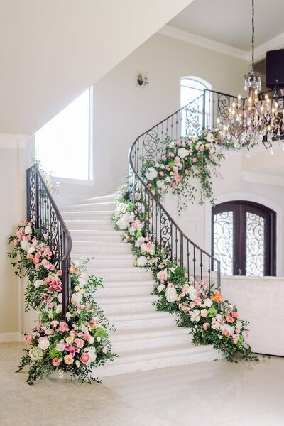 Spring floral design in Austin with greenery and flowers lining the staircase.