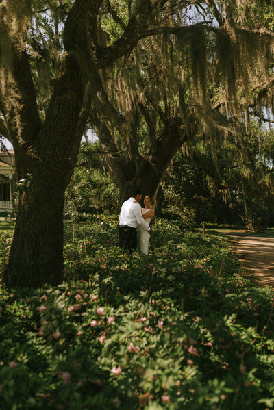 A wedding couple hugging each other in the middle of a wildflower garden at Rip Van Winkle Gardens in Jefferson Island, Louisiana. 