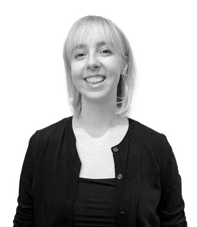 Advanced Senior Stylist with shoulder-length blonde hair, glasses, and a black button-up shirt, specialising in modern hairdressing techniques.
