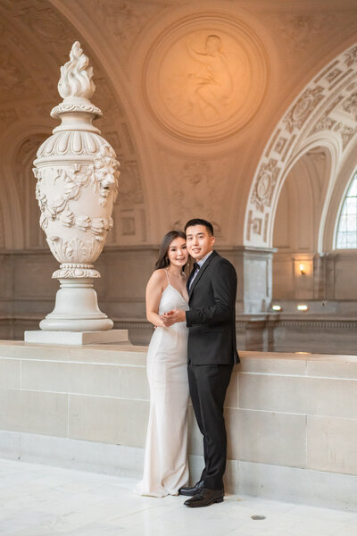 Iconic photograph of a bride and groom walking hand-in-hand through the grand halls of San Francisco City Hall, embodying timeless elegance and love.