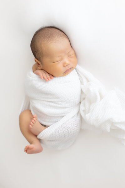 baby wrapped up in white swaddle