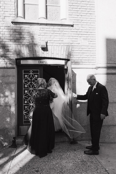 A Bride entering the church with parents holding her dress at St. Patrick's Cathedral in Philadelphia, Pennsylvania. 
