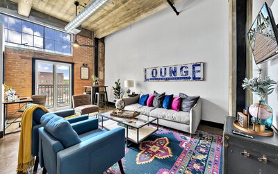Living room with view of downtown in this two-bedroom, two-bathroom vacation rental condo in the historic Behrens building in downtown Waco, TX just blocks from the Silos, Baylor University, and Spice Street.