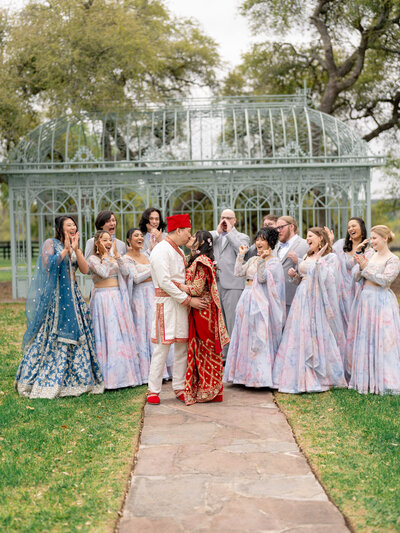 Indian bride and groom with wedding party behind them