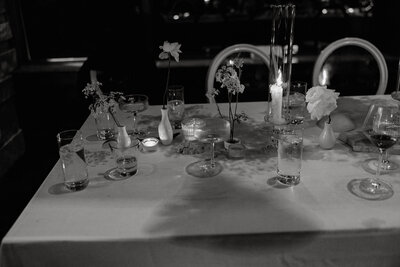 Dimly lit tablescape with minimal florals and glassware