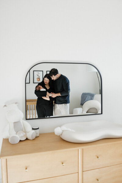 The mother is sitting on the bed, holding a newborn baby in her arms