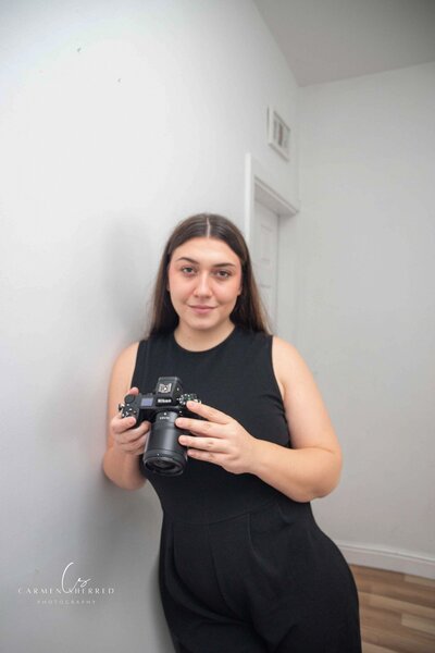 Carmen Sherred, Manchester wedding photographer, holding camera during a wedding day