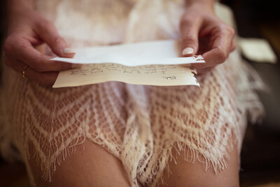shot of bride holding a letter from her groom before they get married