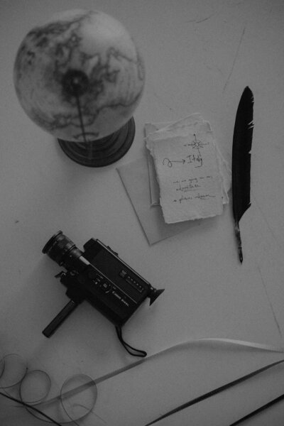 collage of globe, paper, feather, and film camera