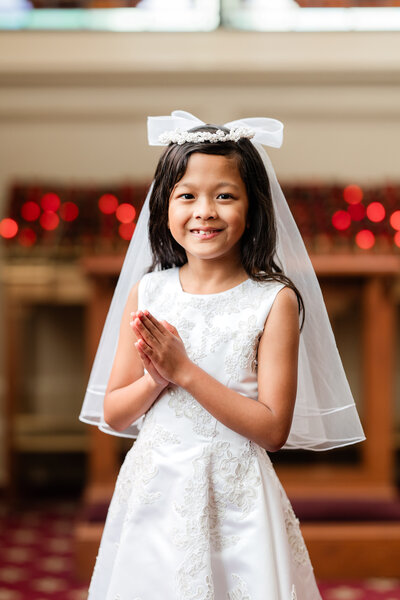 Girl in white dress and veil at religious ceremony in Atlanta.