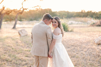 Bride and Groom during golden hour holding hands photographed by Lois M Photography
