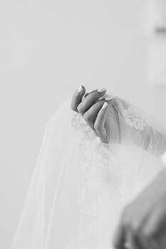 The bride's hand holding her veil.