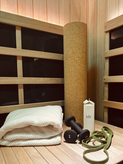 Towel, weights, yoga mat on an infrared sauna bench