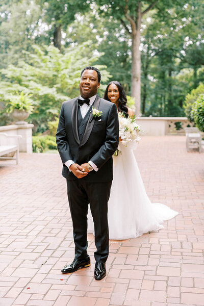 Groom gently holding his Bride hand as they have their first look at Callanwolde Wedding Venue in Atlanta Elizabeth Austin photography  wedding day coordinator Tinted Events Design and Planning