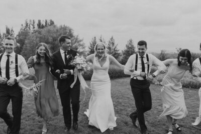 couple running with bridal party