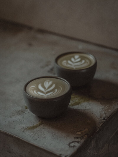 Two mugs of coffee with pattern in the foam