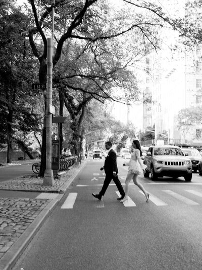 Engagement session snap of the couple crossing the street in the Upper East Side. It is a little blurry and fast paced.