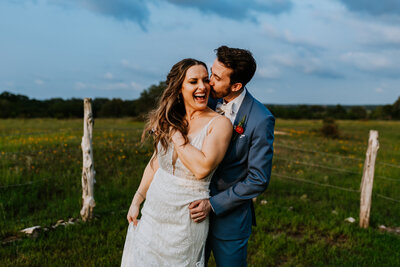 wedding couple laughing in field