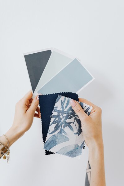 Showit web designer holding swatches of blues and grays on a light gray background