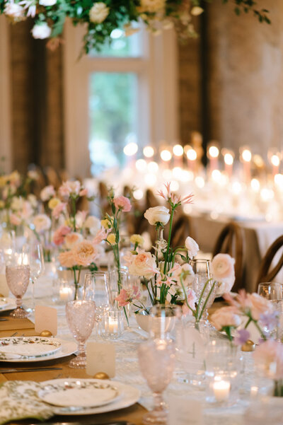 Green tablecloth with pastel floral arrangement and white cake.