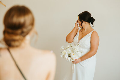 Bride wipes her happy tears away during her first look with bridesmaids at Prairie Hill Vineyard, Ashley Cole Photo