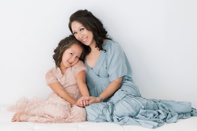 mom and daughter sitting on floor and smiling for photo