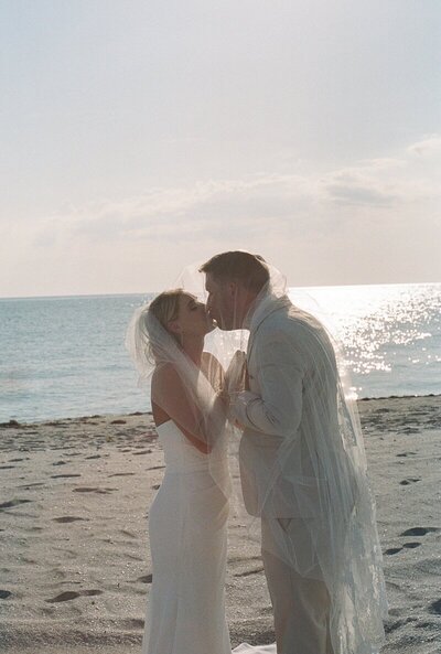 east coast wedding photography of bride and groom kissing on beach taken by Shelby Ann Photos