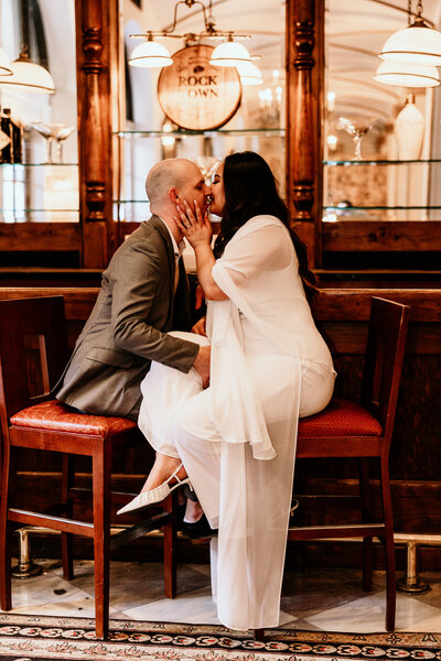 The couple share a steamy kiss while sitting at a hotel bar