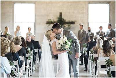Bride and groom share one of their first kisses as husband and wife, photographed by Brooke Bakken.