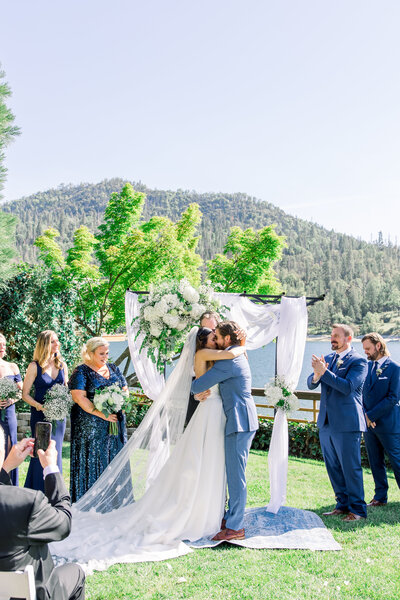 Bride and groom share their first kiss at the Pines in Yosemite Bass Lake
