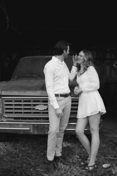 man embracing fiance next to vintage truck for engagement session atlanta