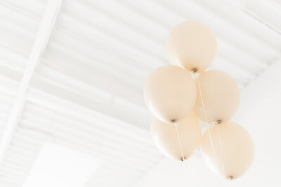 5 balloons floating along a shiplap ceiling