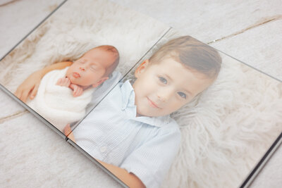 big brother holding newborn brother on the floor