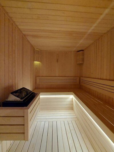 Empty wooden infrared sauna interior at Vitalis wellness studio with warm lighting and bench seating