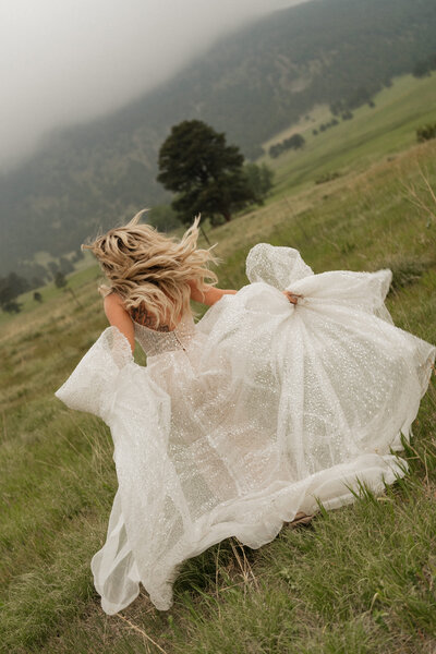 Picture of a bride running through a field taken by a Colorado elopement photographer